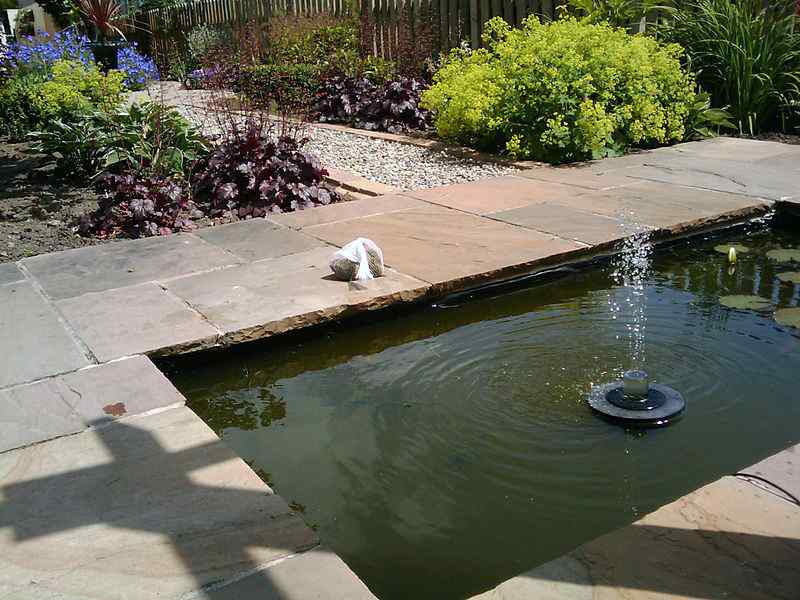 Solar powered outdoor fountain in a garden pond