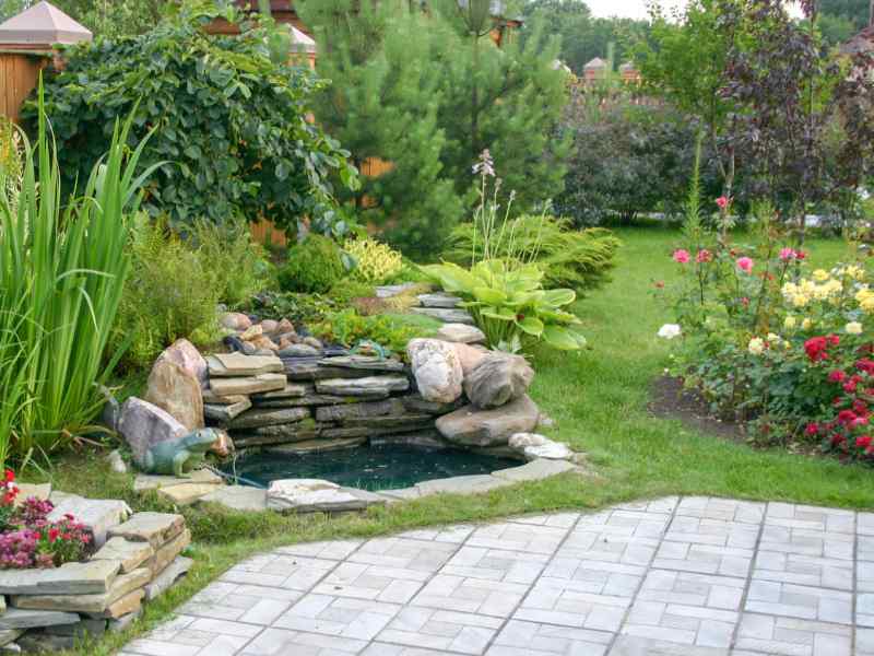 Landscape design with waterfall, patio, and colorful plants
